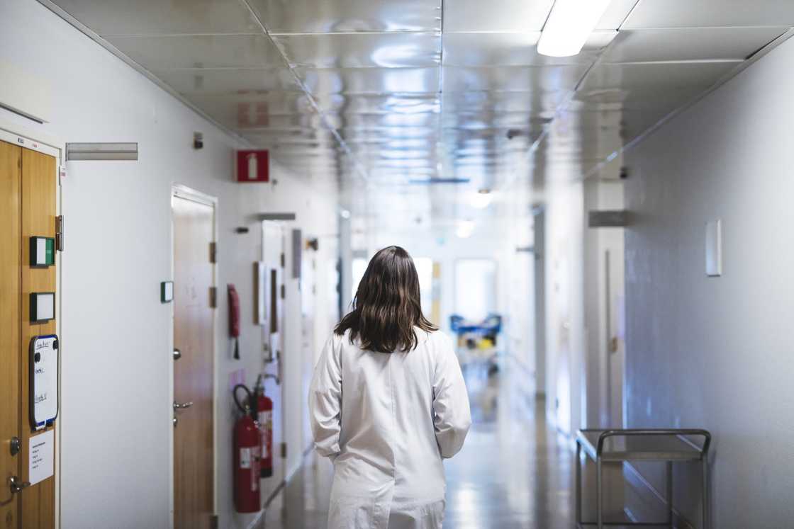 A woman walking through a hospital corridor A woman walking through a hospital corridor