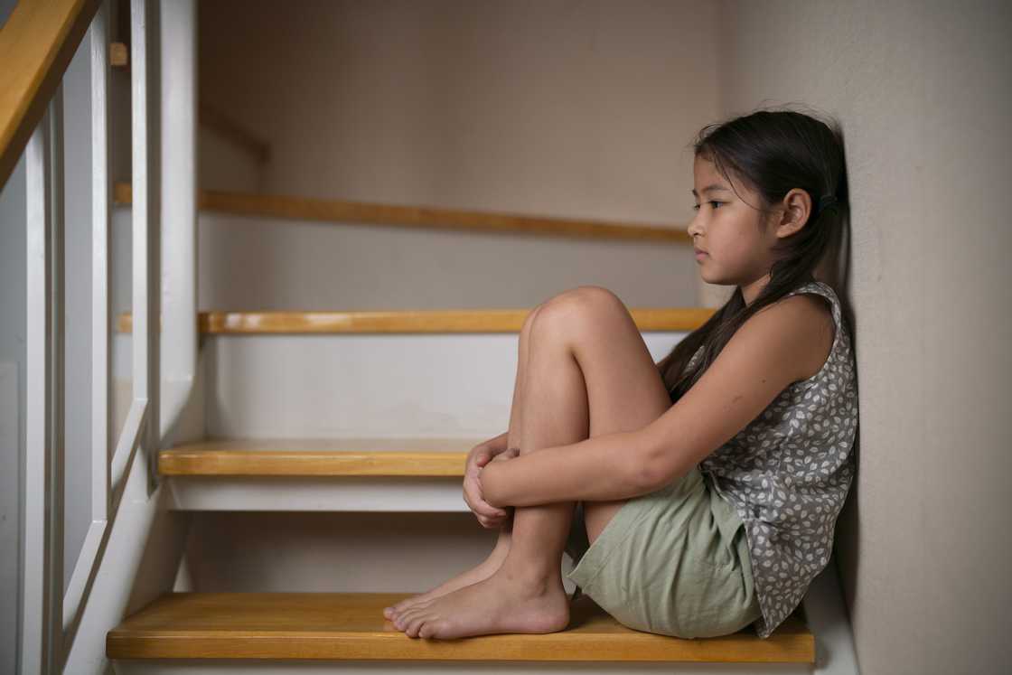 A young girl sits on the stairs A young girl sits on the stairs