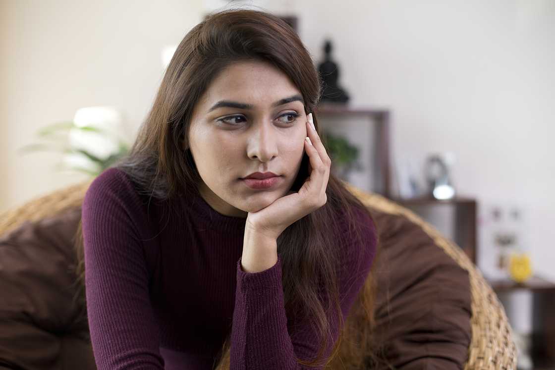 A young woman sitting at home thinking