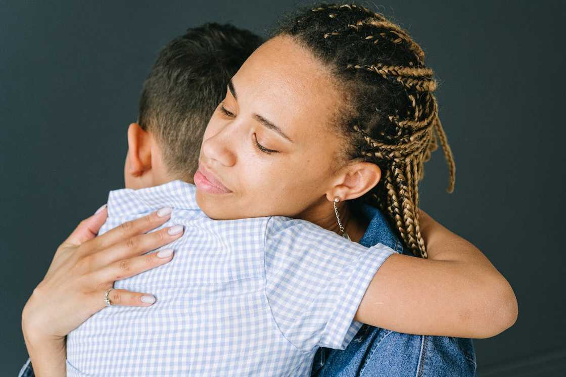 Woman hugging a child in a comforting embrace. Woman hugging a child in a comforting embrace.