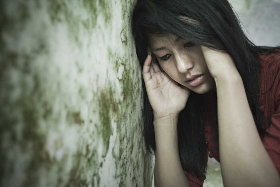 A girl leaning against a dirty wall A girl leaning against a dirty wall