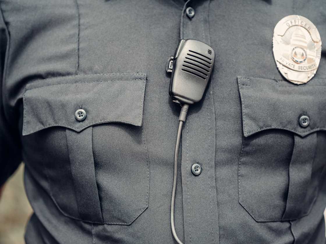 Close-up of a police man with a uniform and a radio.