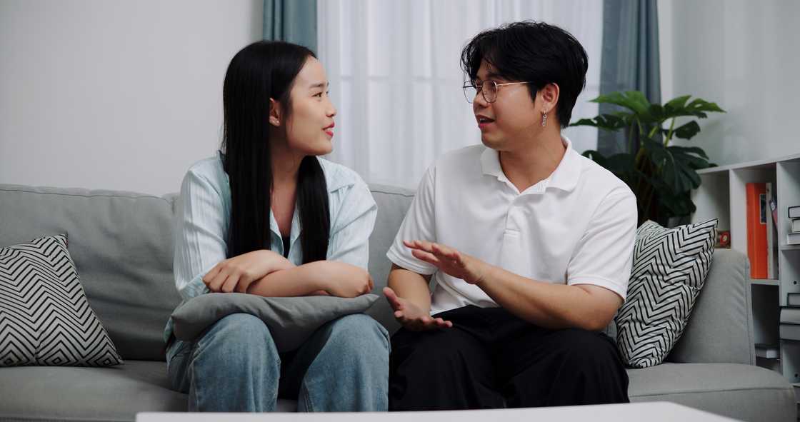 A couple talking while sitting on sofa