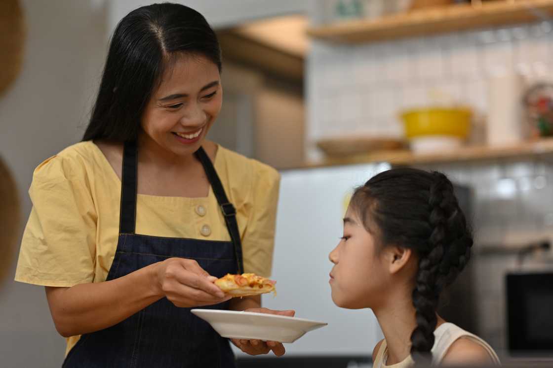 A mother sharing homemade meal with daughter