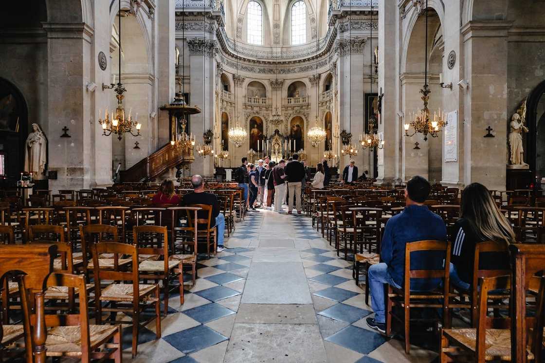 Interior of a large historic church with rows of wooden chairs. Interior of a large historic church with rows of wooden chairs.