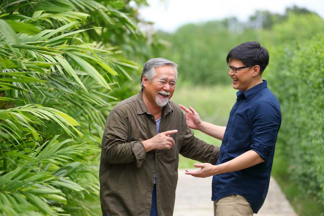 A man laughing out loud with his son while talking A man laughing out loud with his son while talking