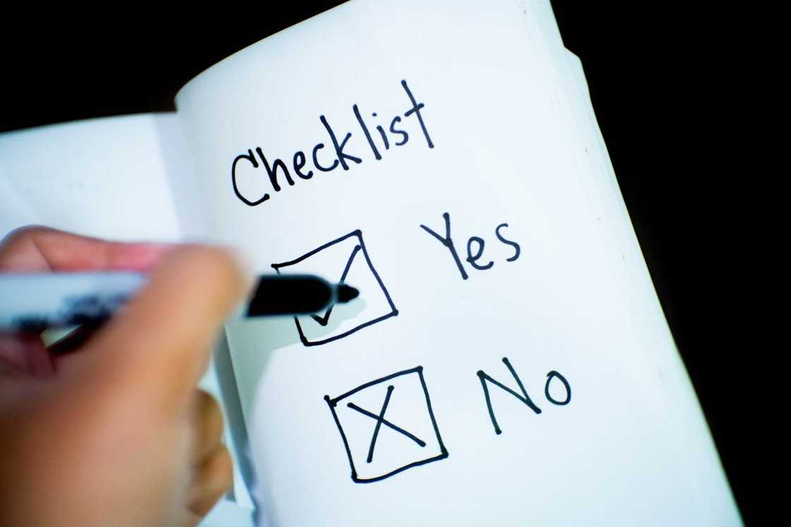 A hand ticking “Yes” on a handwritten checklist. A hand ticking “Yes” on a handwritten checklist.