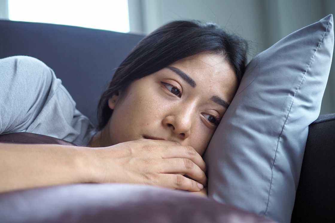 A sick young woman lying in bed