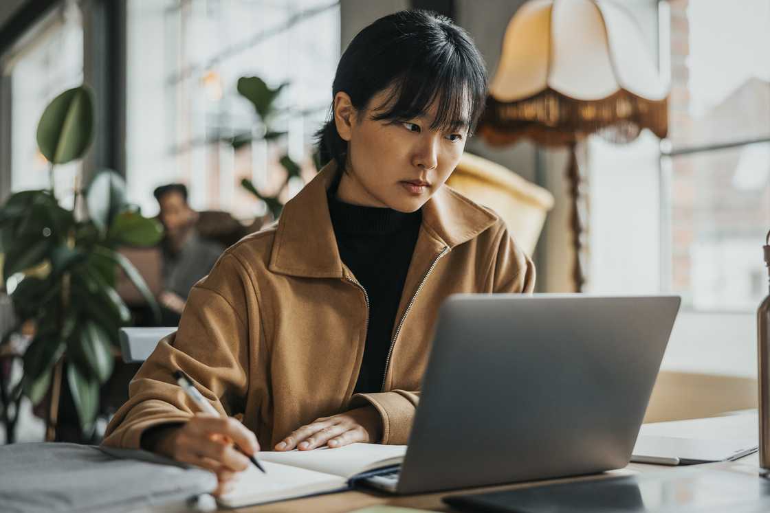 A lady is journaling at a cafe A lady is journaling at a cafe