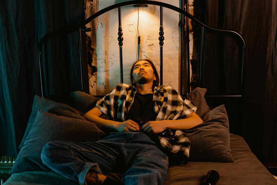 A man in deep thoughts on the bed. A man in deep thoughts on the bed.