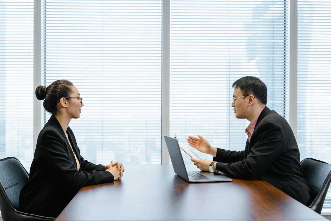 A man and woman talk privately in an office.