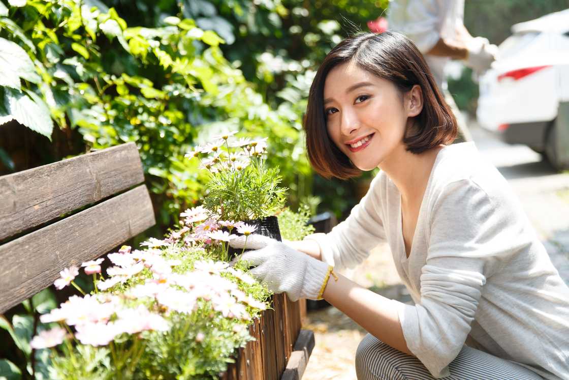 A relaxed woman holding plants crate