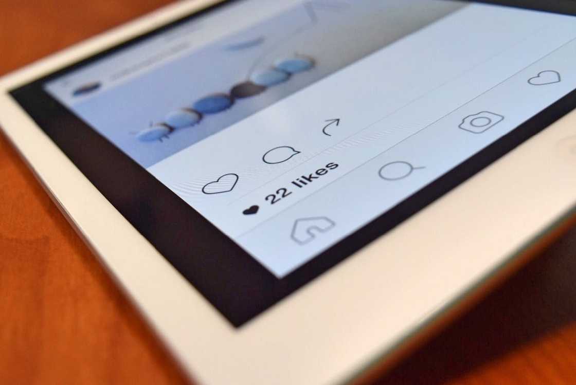 A tablet screen shows a social media post with visible engagement icons and a like count.
