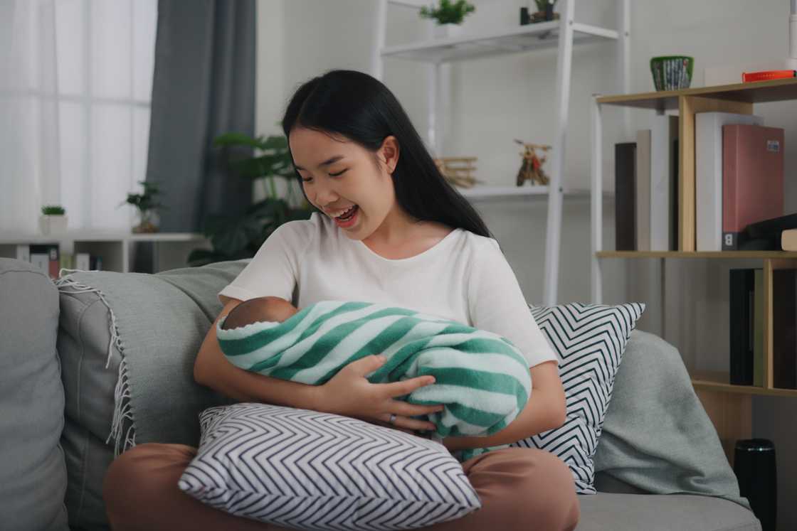 Portrait of a young Asian mother holding her newborn