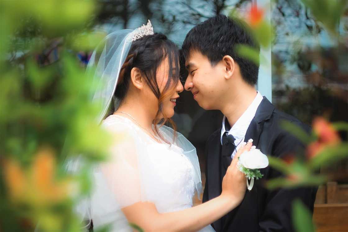A bride and groom embracing during a private wedding moment. A bride and groom embracing during a private wedding moment.