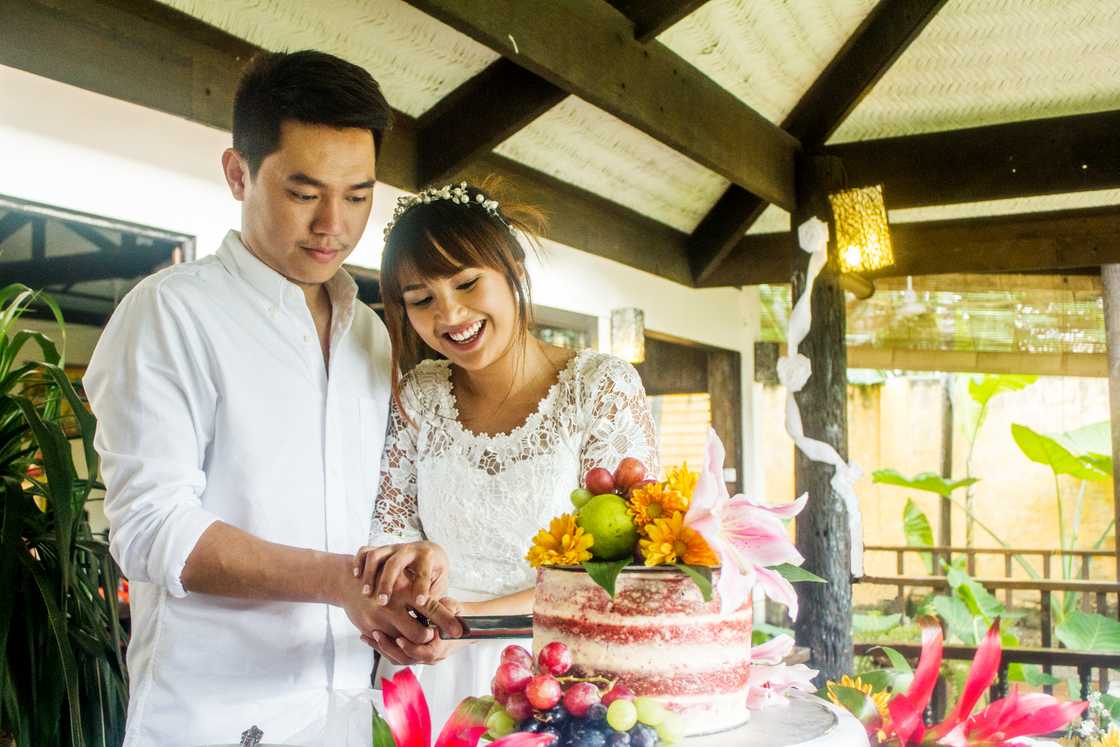 A couple is slicing their cake