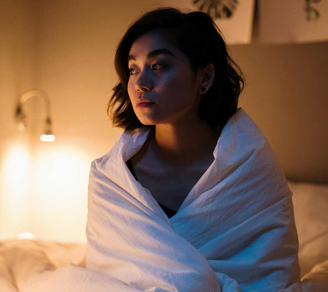 A distressed woman sitting on the edge of the bed