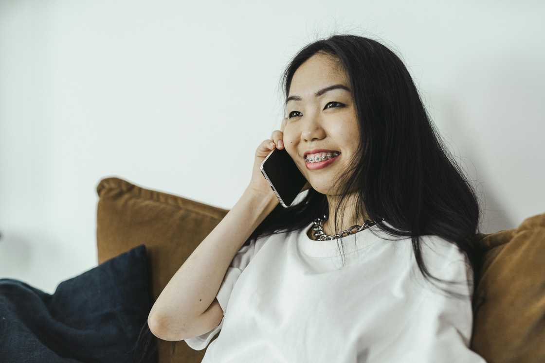 A smiling woman talking on a phone call A smiling woman talking on a phone call