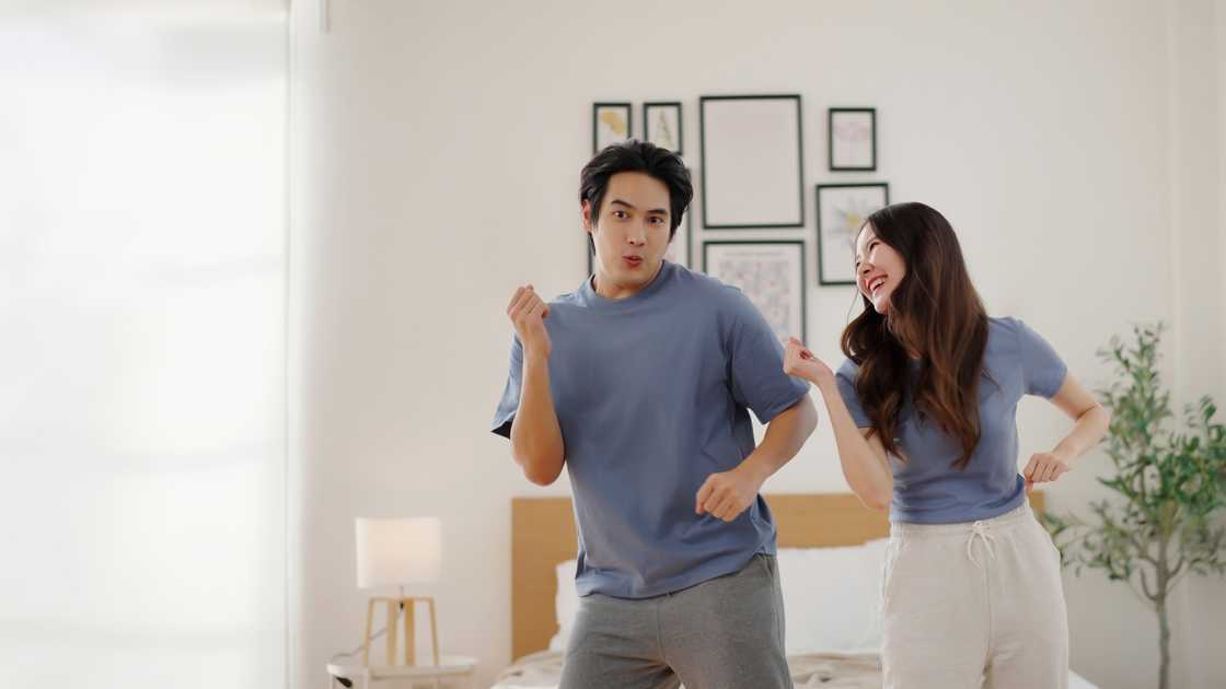 A happy couple dancing together at home