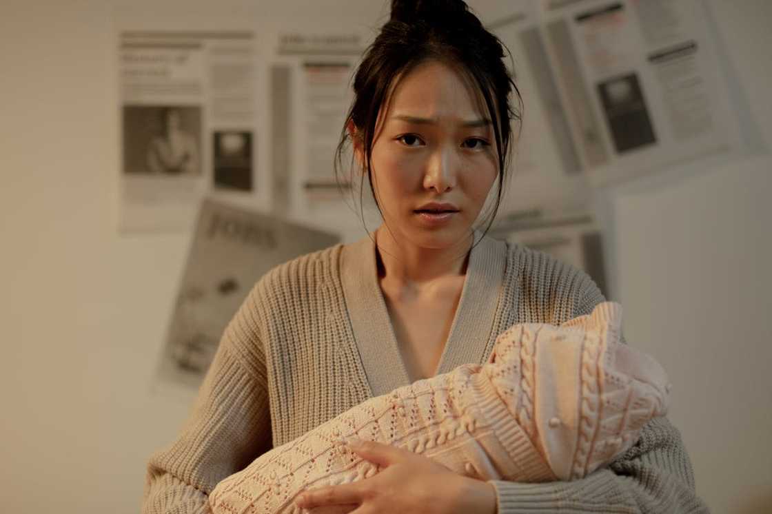 A woman holds her newborn baby on her chest.