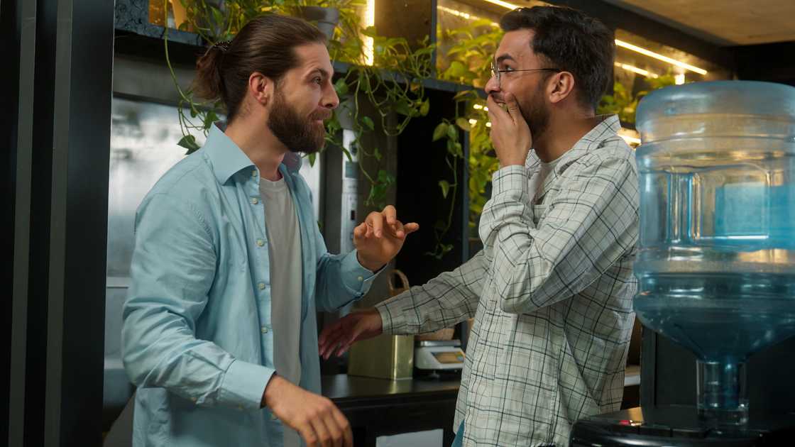 Employees gossiping in an office Employees gossiping in an office