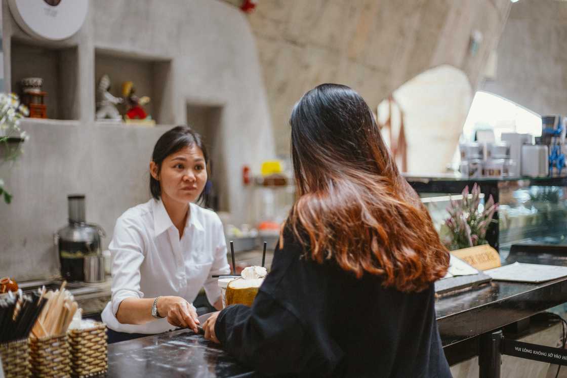 a woman in a shop serving customers a woman in a shop serving customers