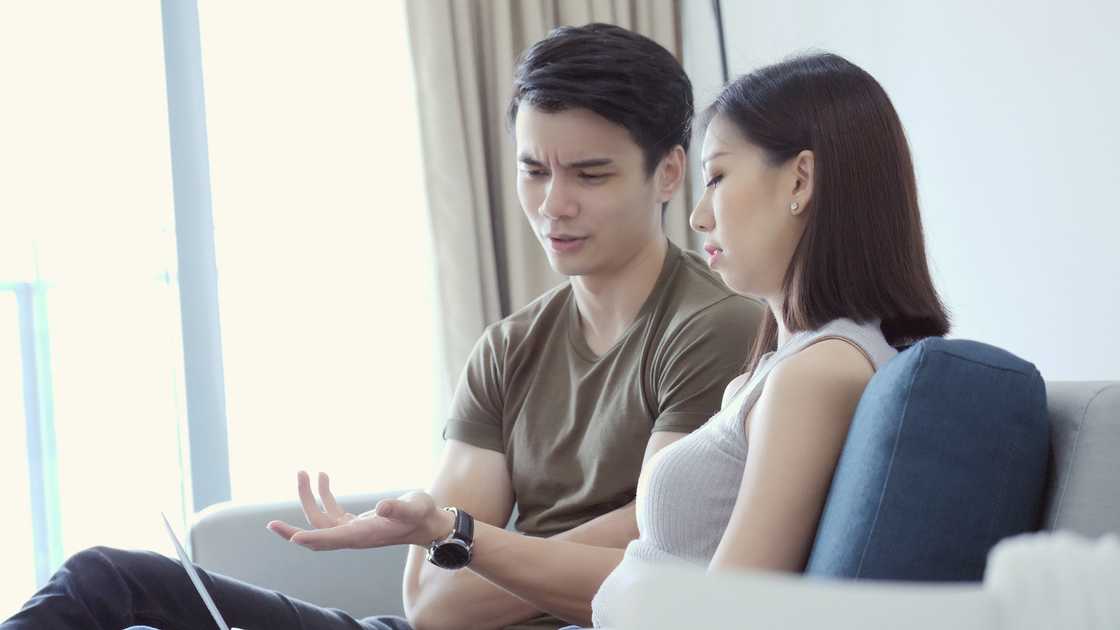 A couple arguing while sitting on a couch
