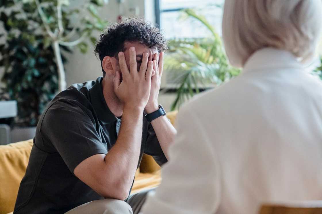 A therapist speaks to a man during a counselling session. A therapist speaks to a man during a counselling session.