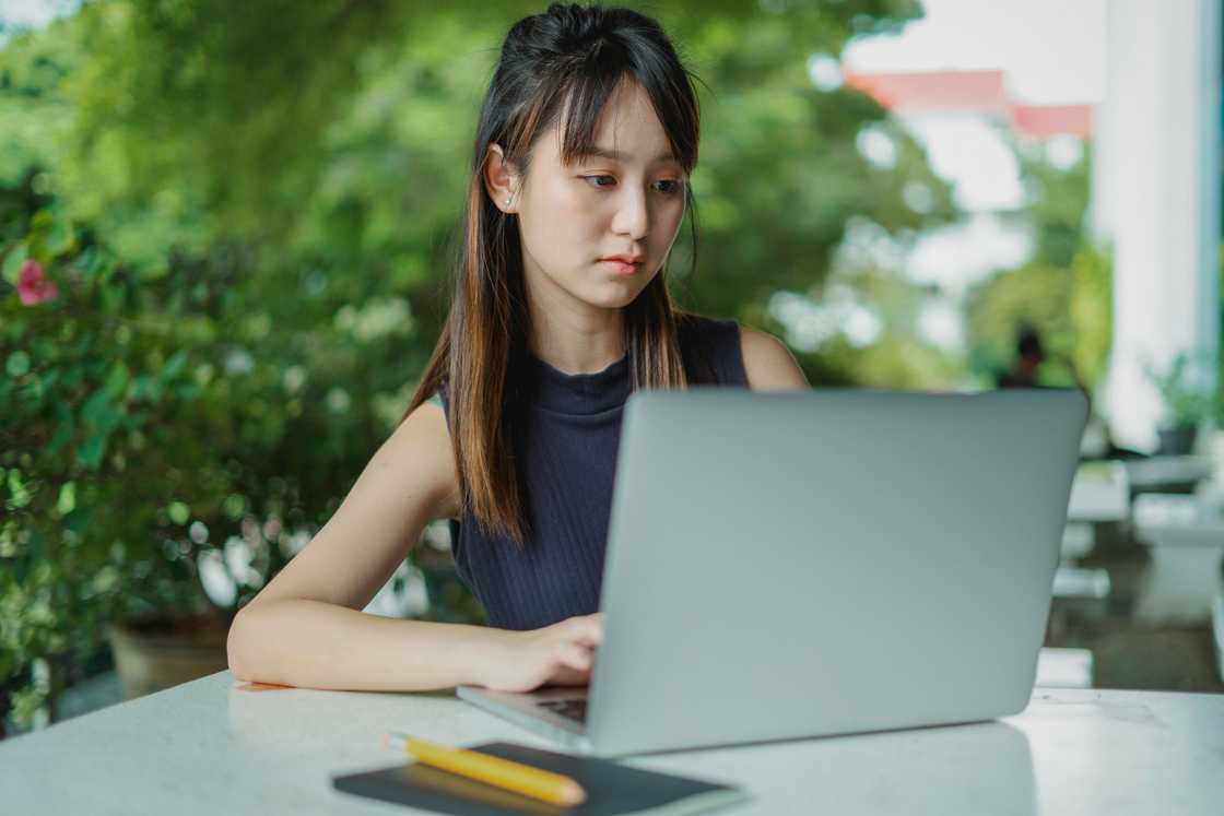 A serious woman typing something on her laptop