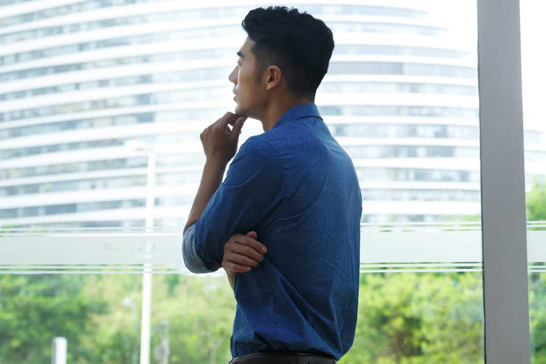 A man thinking while looking outside the window
