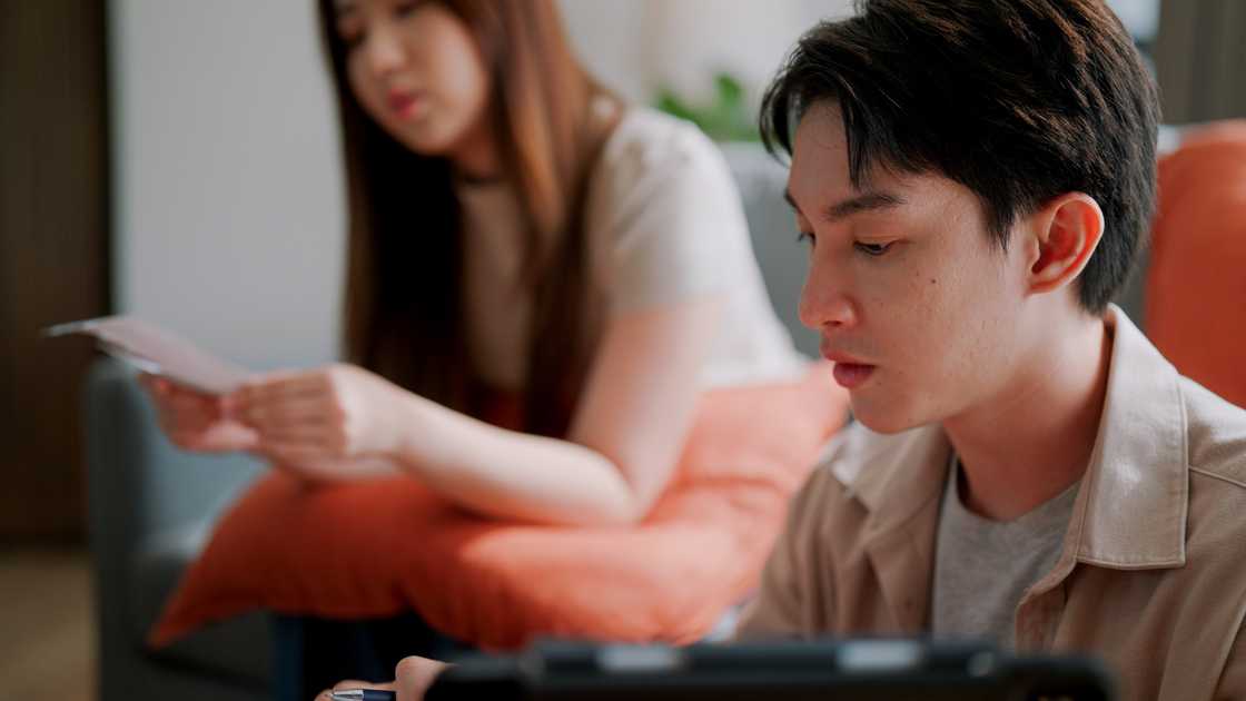 A couple is reading bills at home A couple is reading bills at home