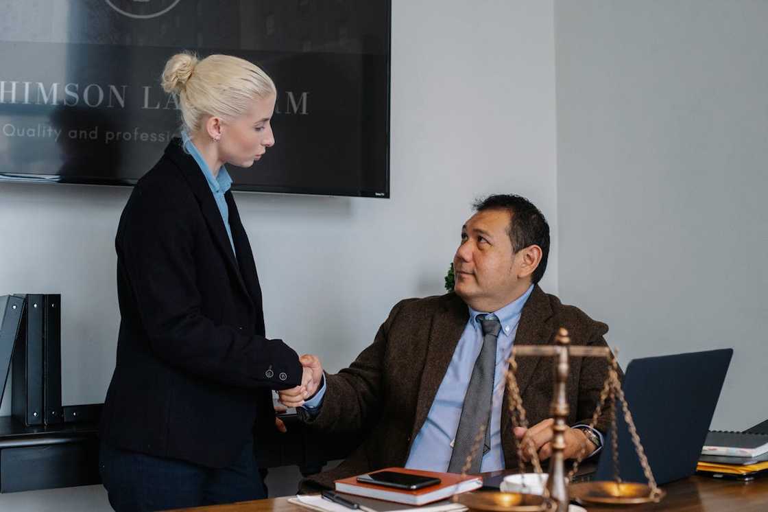 Lawyers shake hands in an office.