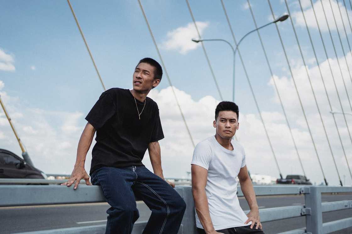 Two young men pose on a modern bridge. Two young men pose on a modern bridge.