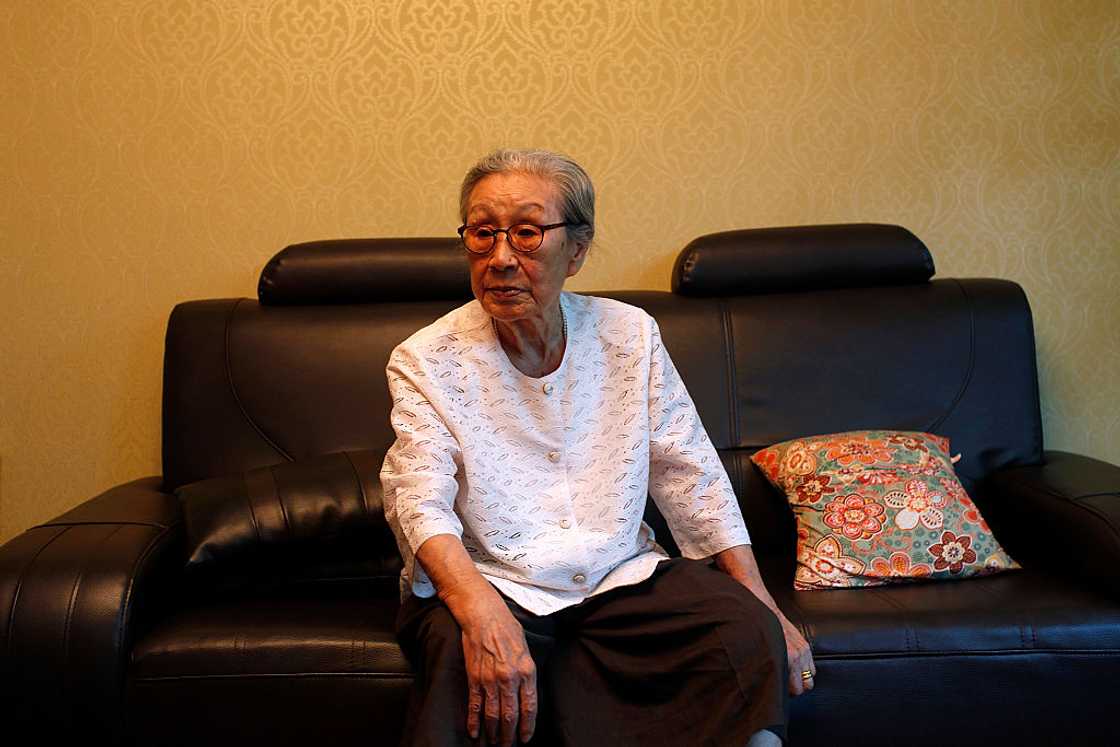 Old Asian woman sits indoor Old Asian woman sits indoor