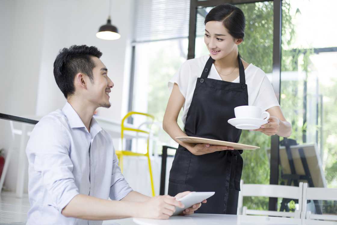 A waiter and a client in a coffee shop