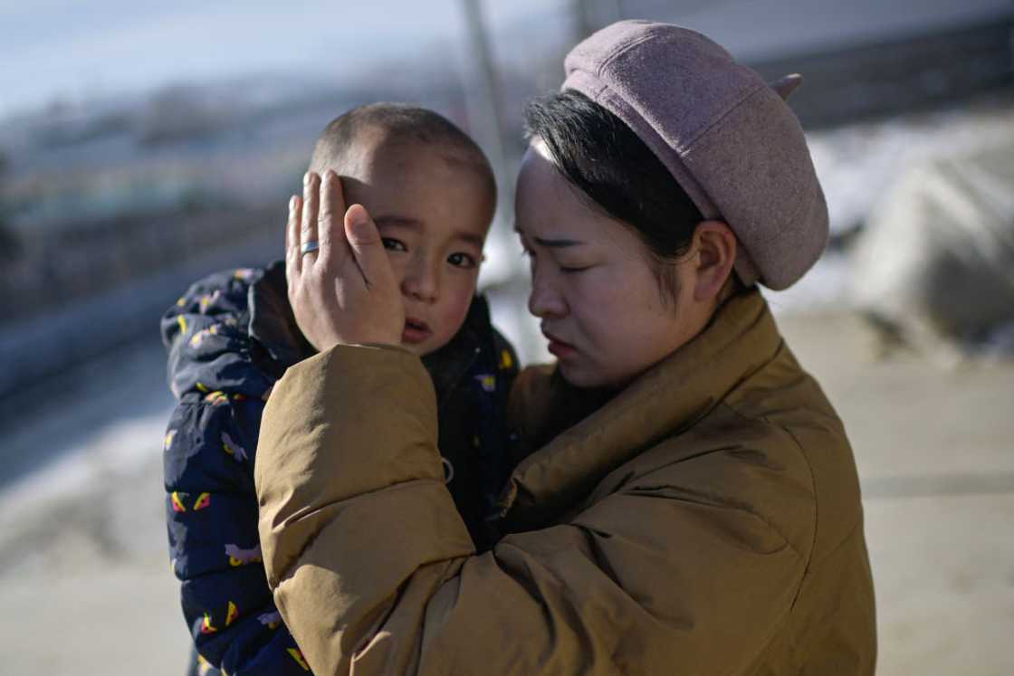 Mother carrying her boy child.