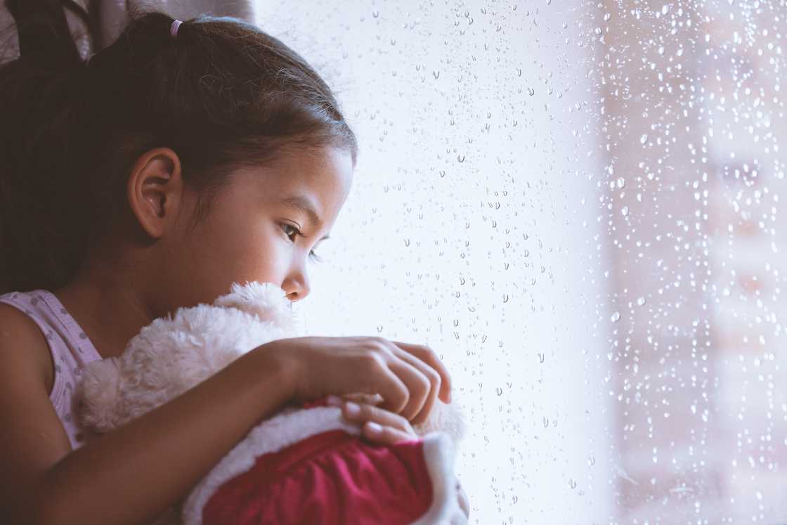 A sad girl is holding her stuffed toy A sad girl is holding her stuffed toy