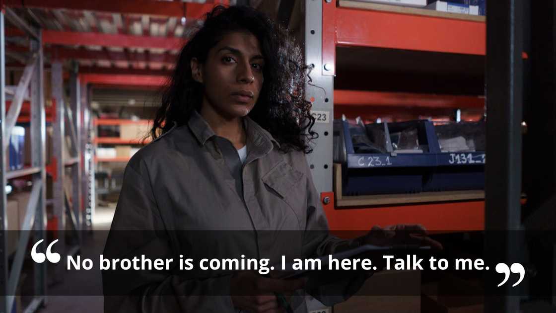A woman holding a clipboard while standing in a workshop.
