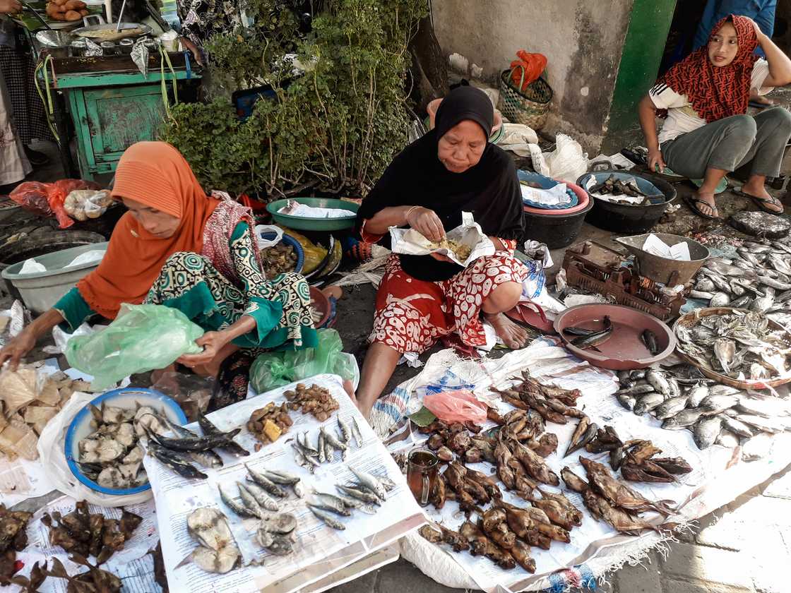 A woman selling smoked fish in the market