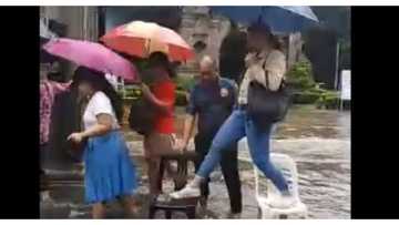 Mga pulis sa may UST, hinangaan sa pagtulong sa mga taong makadaan sa baha nang di nababasa