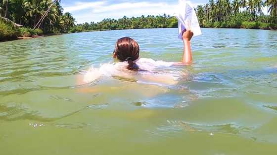 Guro, nilangoy ang hanggang leeg na ilog para mahatid ang module sa mga estudyante